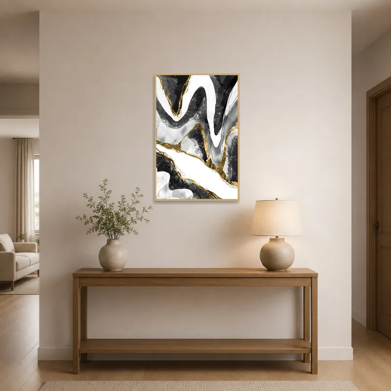 Abstract black and gold wave art print in an entrance hall with modern decor.