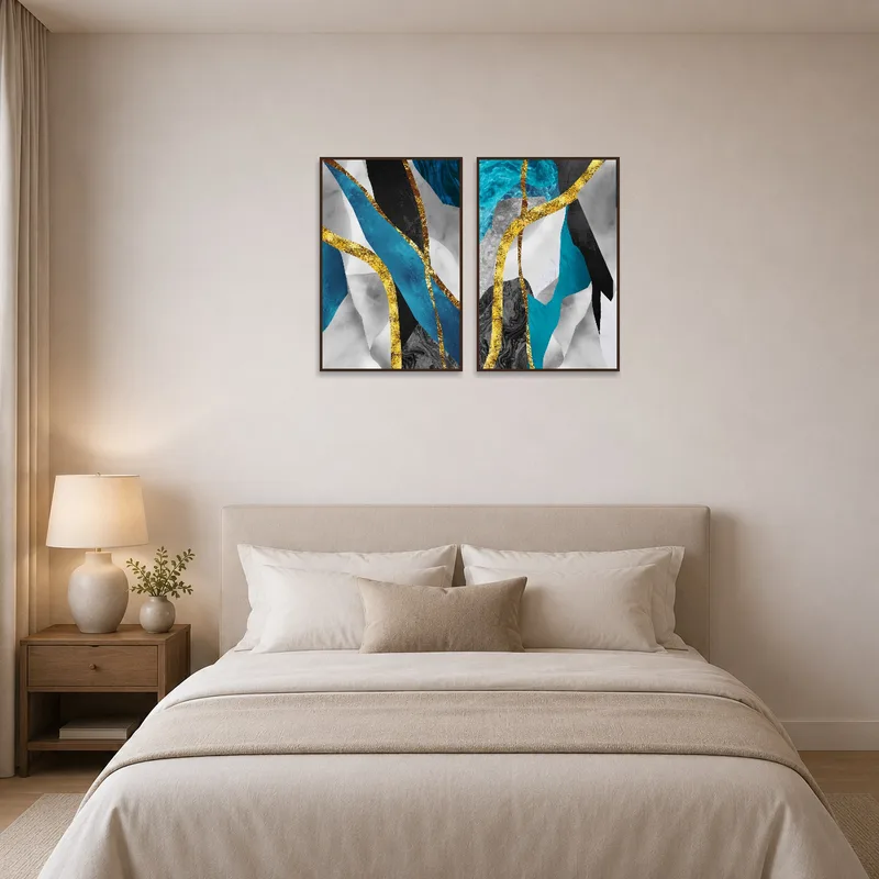 Abstract wall art set with blue and gold textures hung over a bed.