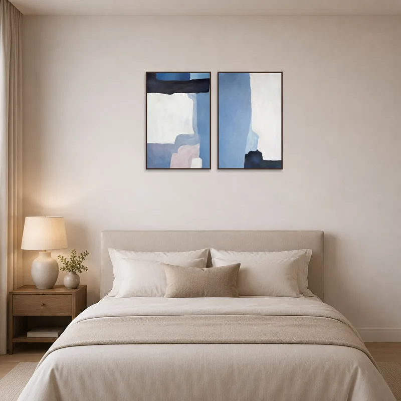 Abstract blue and white art set adding elegance to a bedroom wall above the bed.