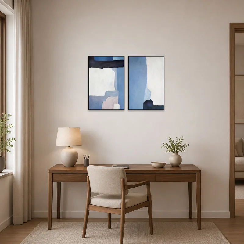 Home office space with abstract blue and white tones art set on the wall behind the desk.