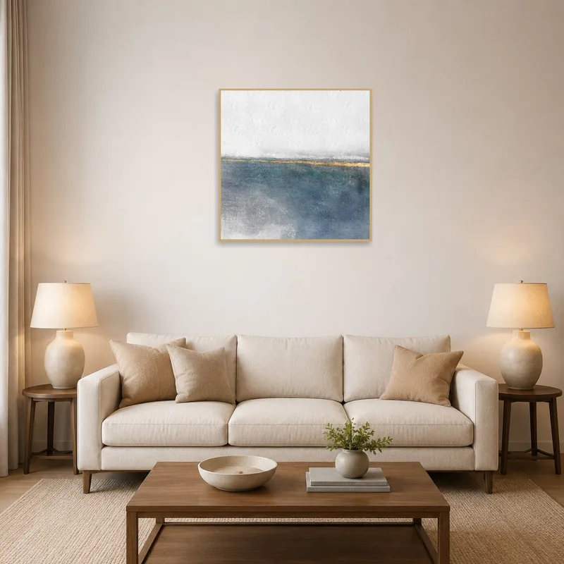 Abstract coastal art piece above a modern sofa in a living room.