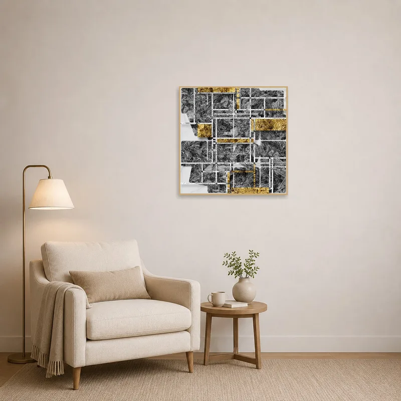 Reading corner adorned with a geometric art print in gold and gray above a cozy chair.