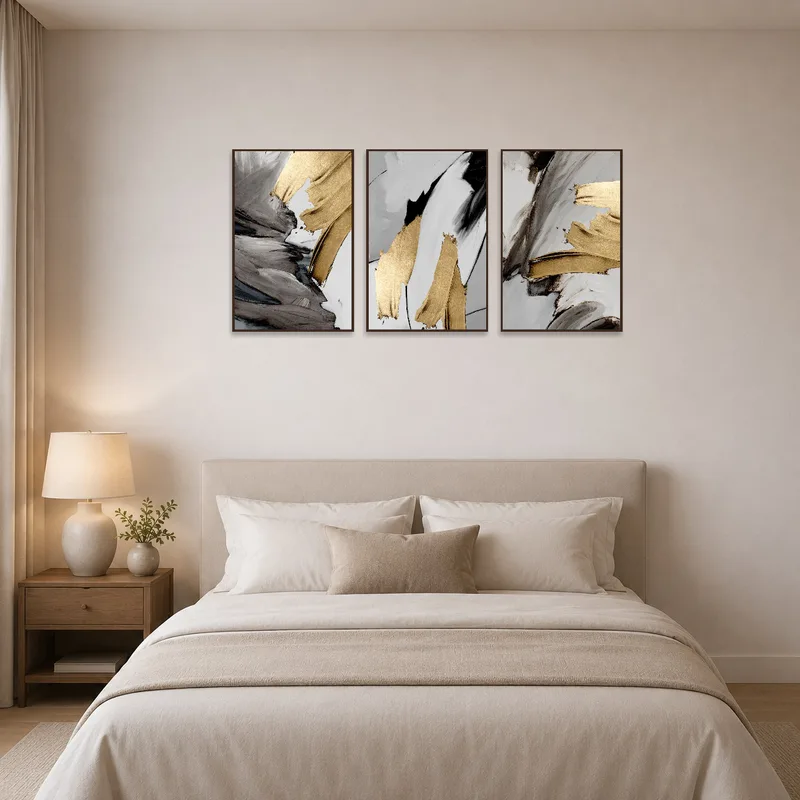 The bedroom wall boasts a soothing trio of gold and gray abstract designs.