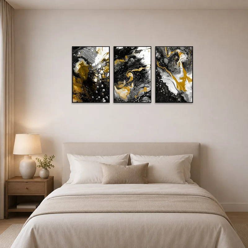 Bedroom wall adorned with abstract triptych in gold, black, and white above the bed.