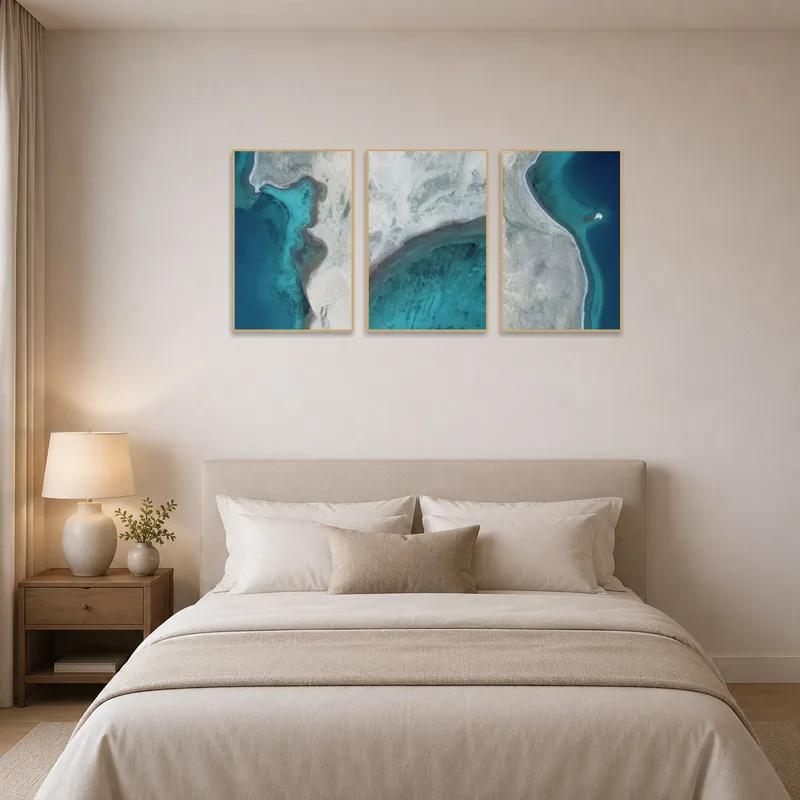 Bedroom wall with calming aerial coastal triptych for a peaceful sleep environment.