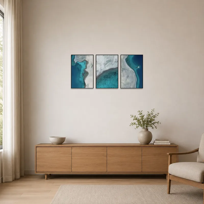 Minimalist room with a calming aerial coastal triptych bringing elegance to the space.