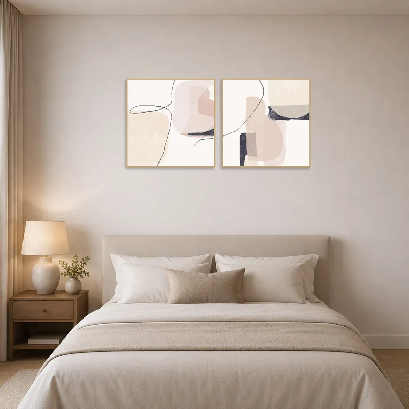 Soft neutral abstract works creating a tranquil bedroom atmosphere.