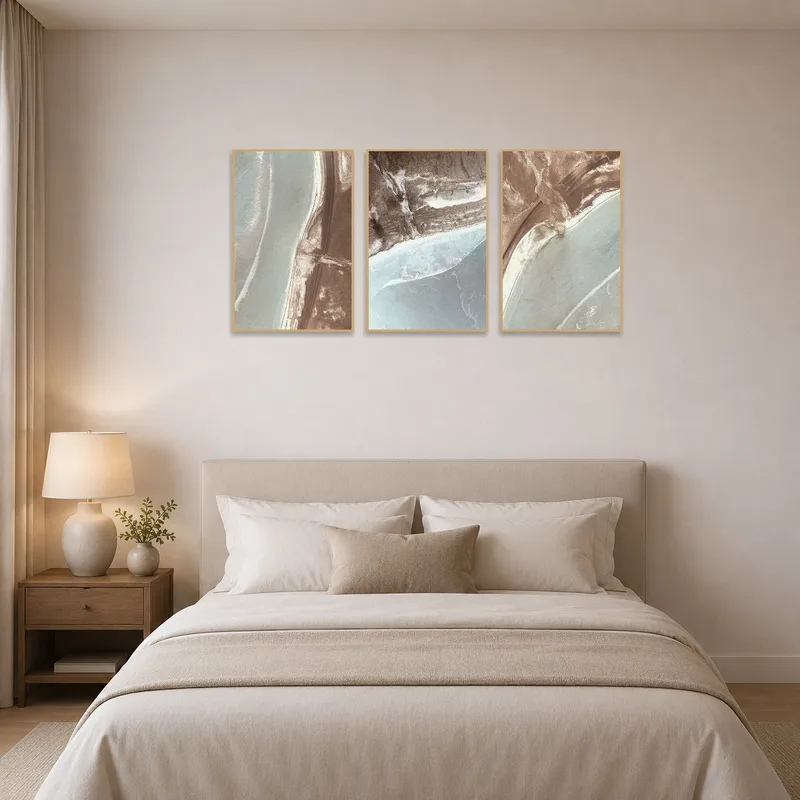 Earthy tones of aerial landscapes adding warmth to a bedroom wall.