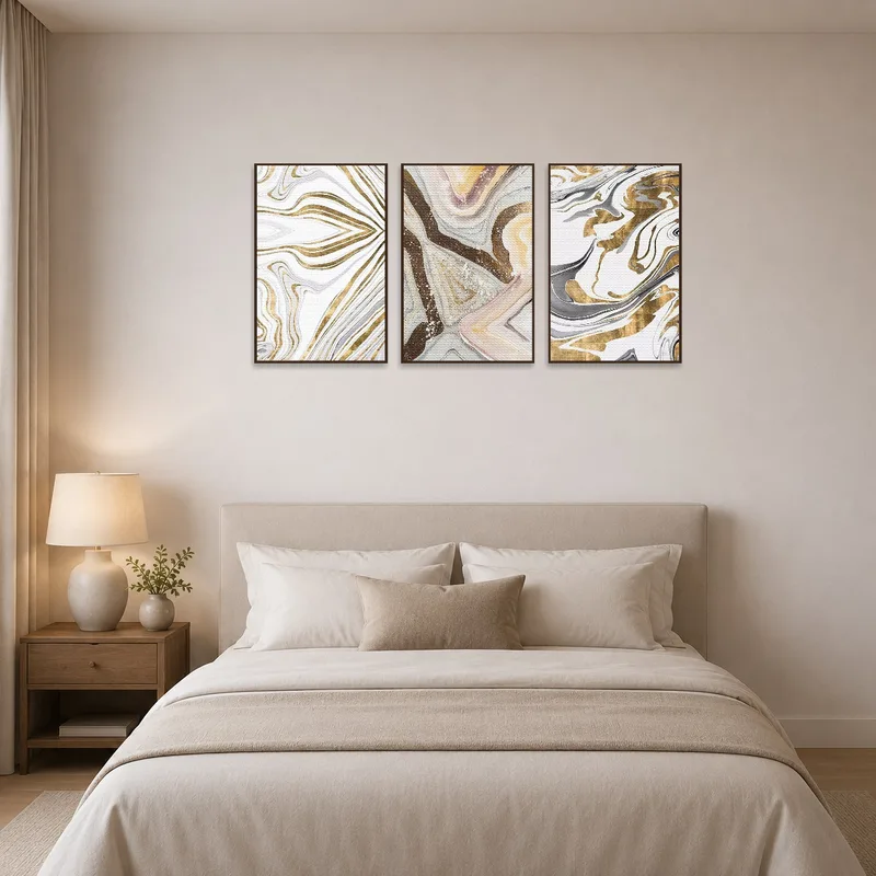 Soothing earth tones triptych above a bed with plush linens.