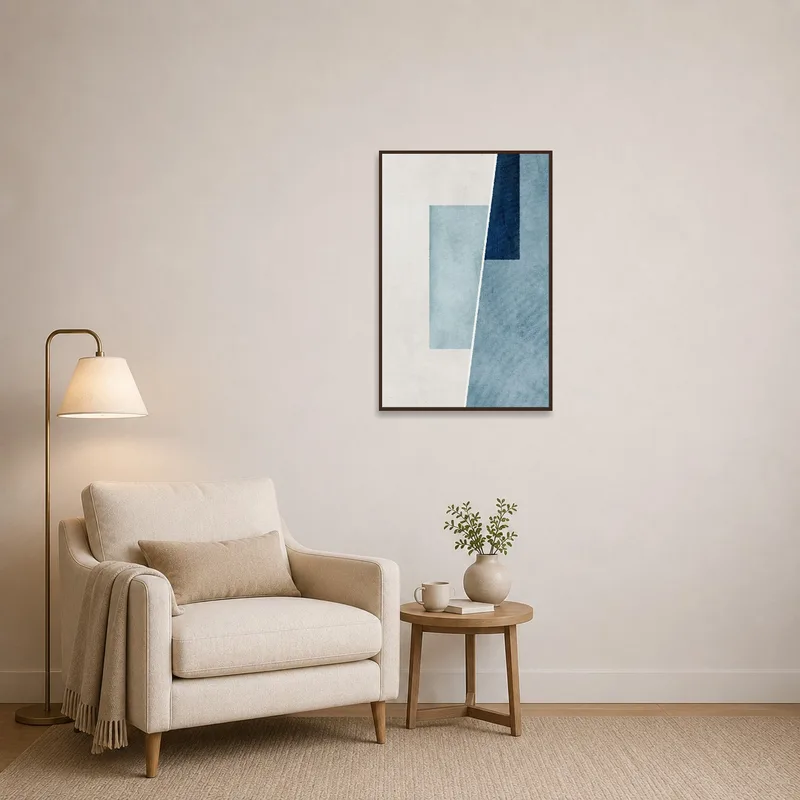Blue abstract artwork creating a serene atmosphere in a cozy reading corner with a comfy chair.