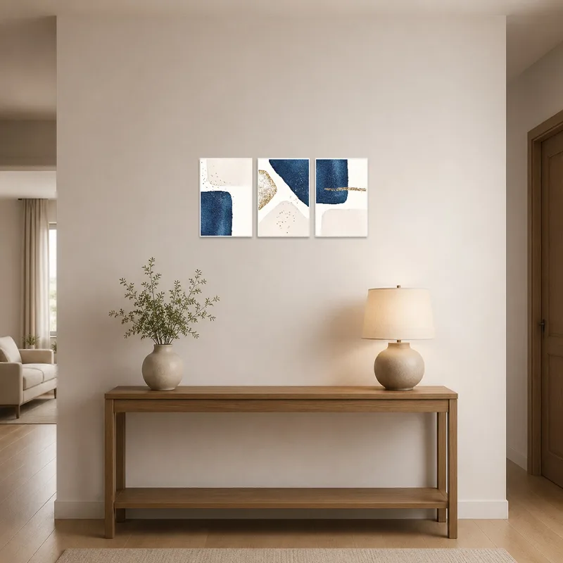 Navy and gold abstract triptych hanging in a stylish entrance hall.