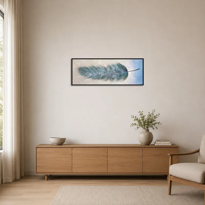Blue feather artwork adds a touch of color to a minimalist white wall.