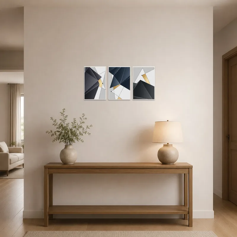 A geometric abstract gold and grey print hanging in the entrance hall near a small console table.
