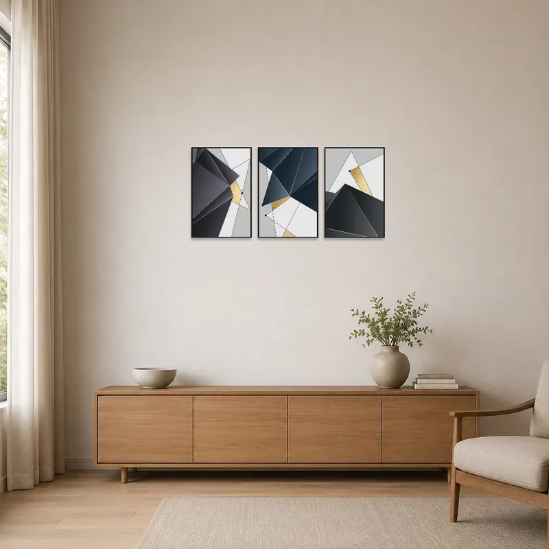 A geometric abstract gold and grey print set against white walls and minimal furniture.
