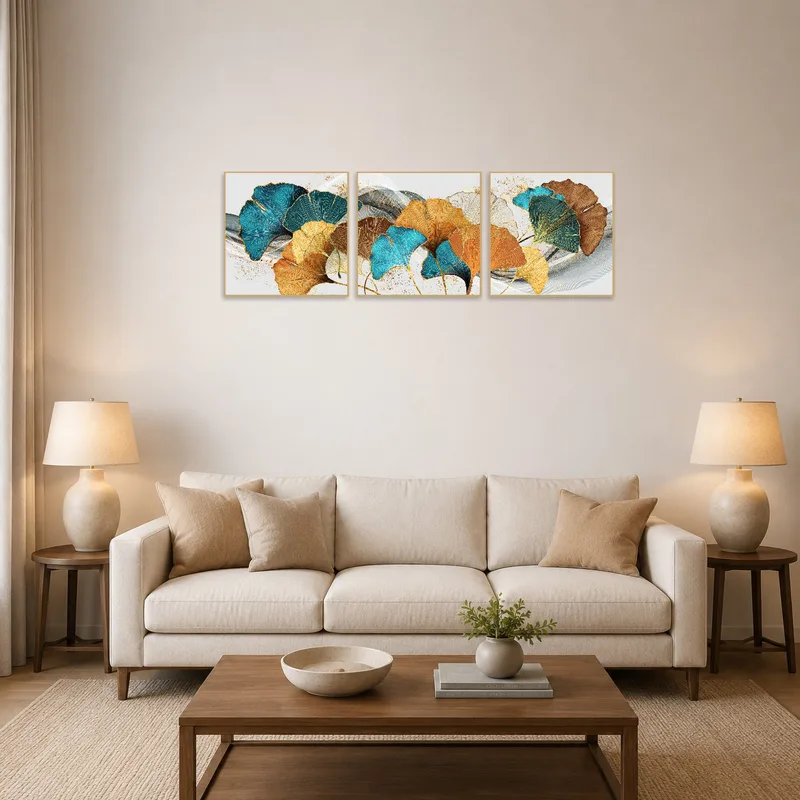 A turquoise and gold ginkgo leaf triptych adorns the living room wall, adding elegance above a cozy sofa.