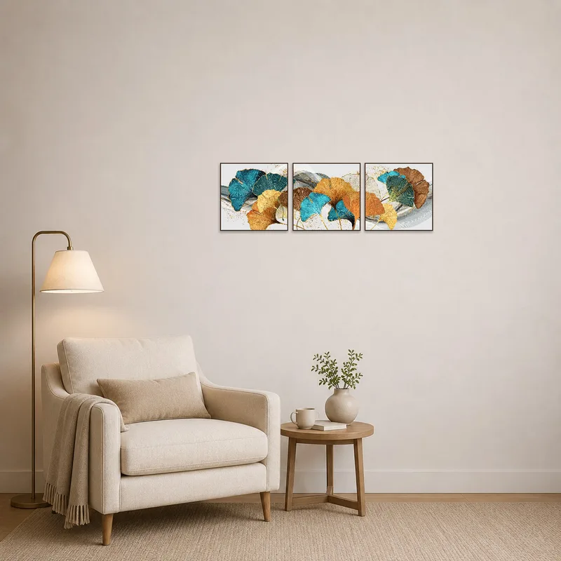 A reading corner is brightened by the turquoise and gold ginkgo leaf triptych, offering a serene background for relaxation.