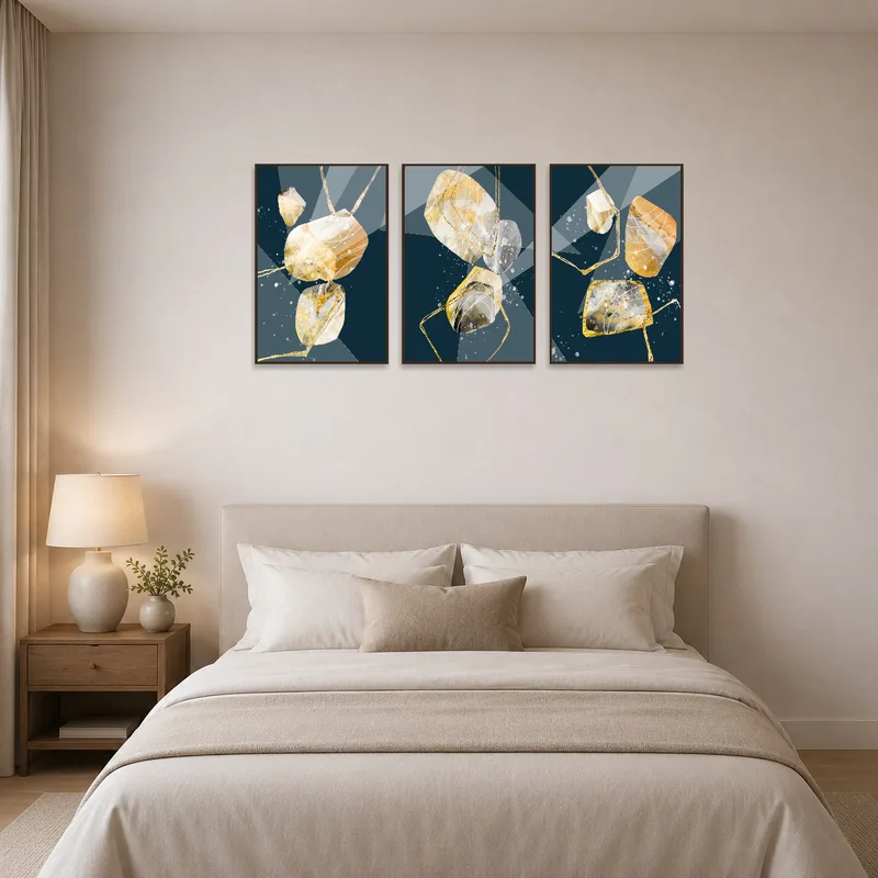 Golden abstract geometric triptych set hung above a bed with soft, neutral bedding.