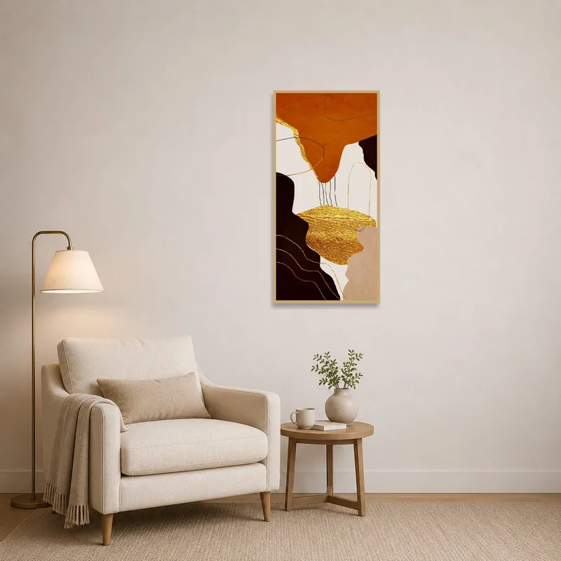 Golden abstract art enhances a cozy reading corner with a plush chair and lamp.