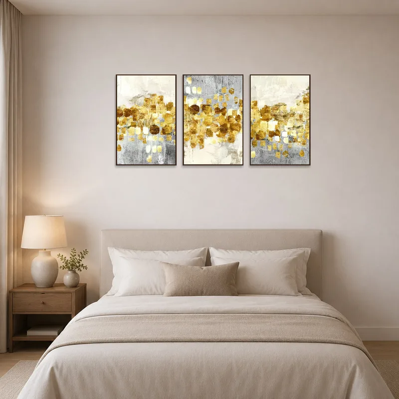 Golden abstract triptych with metallic brushstrokes adding elegance to a bedroom.