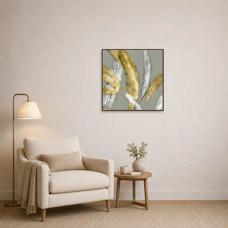 Golden and silver feather art brings tranquility to a cozy reading corner with an armchair.