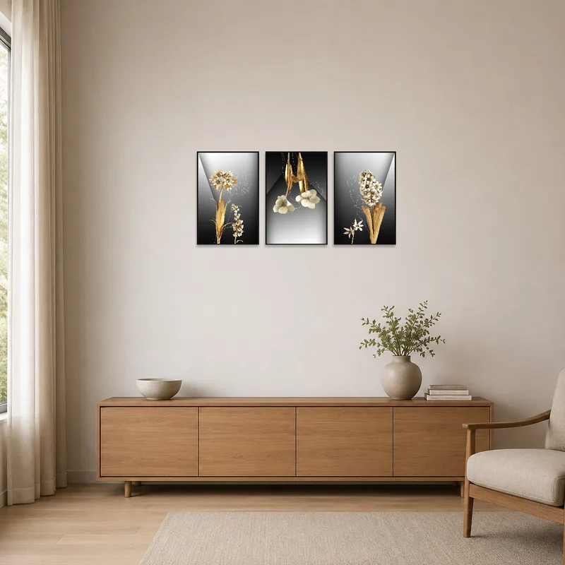 Golden floral triptych on a clean white wall in a minimalist space with a single chair.