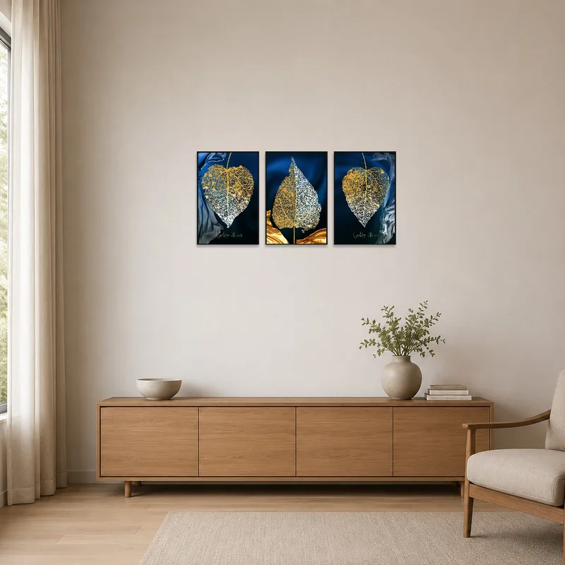 Golden leaves triptych in a minimalist space with white walls and simple furnishings.