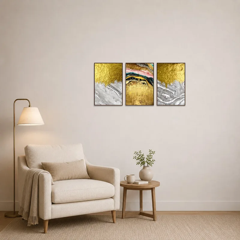 Luxe triptych with gold accents hanging in a cozy reading corner with a plush chair.