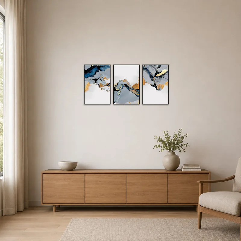 Blue and gold abstract prints on a white wall in a minimalist room.