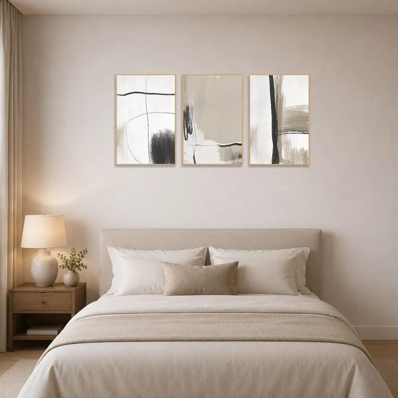 Monochrome abstract triptych set displayed above a serene bedroom setting.