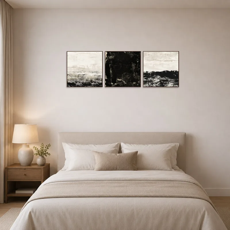 Monochrome abstract triptych with textured layers in a bedroom setting.