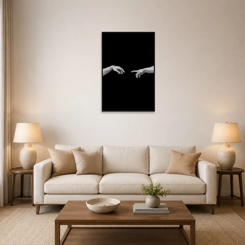Art print of monochrome hands on black background above a modern living room sofa.