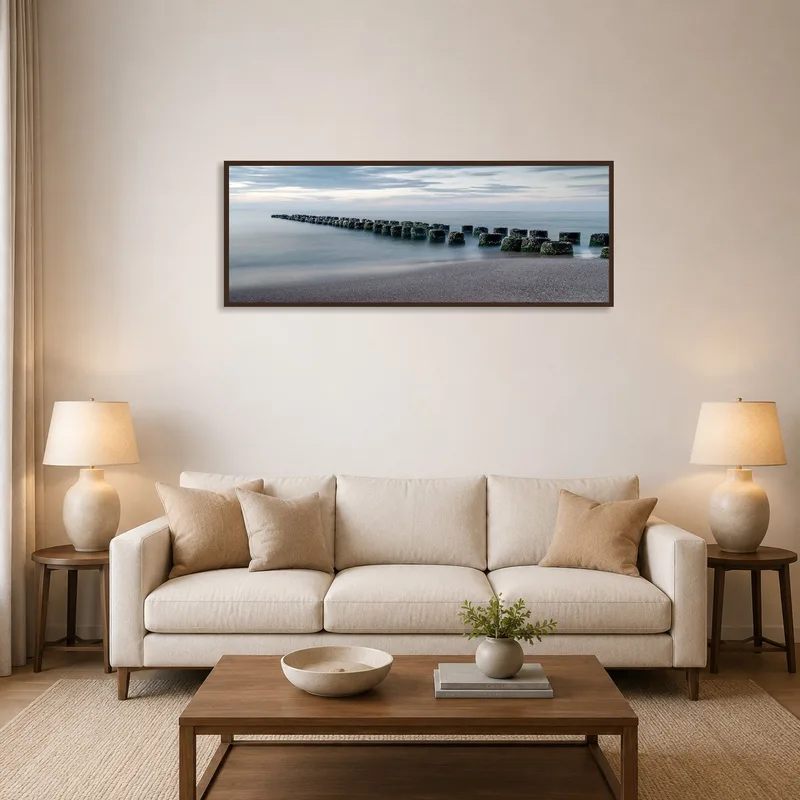 A serene coastal view with stone breakwaters hanging in a cozy living room.