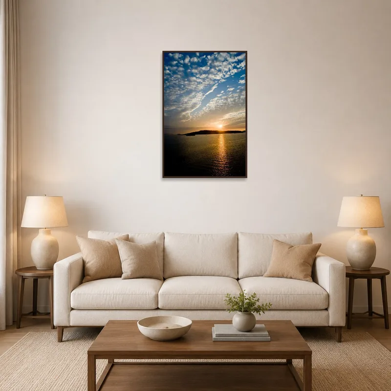 Artwork of sunset over water and clouds in a cozy living room.