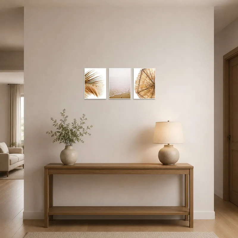 Set of beach and palm images in an entrance hall above a sleek console table.