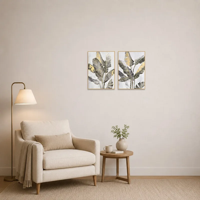 Reading corner enlivened by a tropical leaf art set in gold and gray, bringing tranquility.